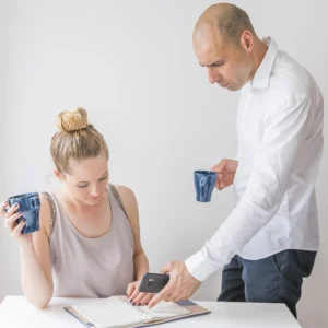 woman-looking-businessman-holding-calculator-pointing-diary